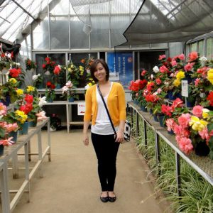 Elizabeth Kataoka full body shot in a greenhouse with potted flowers