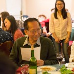 Man smiling at another person off camera at a restaurant gathering