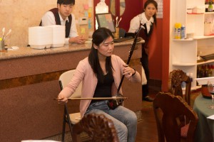 Woman in pink cardigan playing an instrument