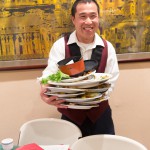 Waiter holding a mountain of dishes