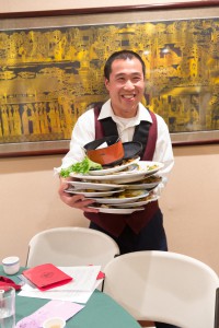 Waiter holding a mountain of dishes